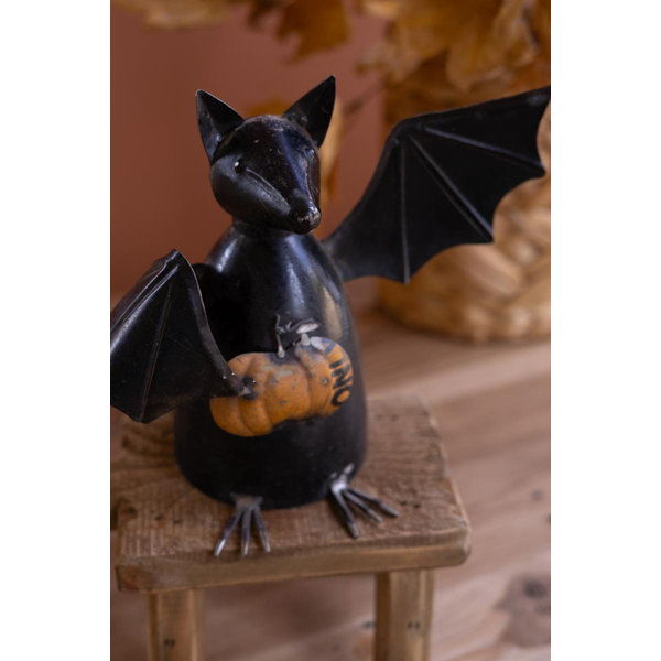 RECYCLED METAL BAT HOLDING A PUMPKIN